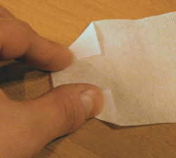 Die unteren beiden Ecken gedrittelt einfalten / Fold the lower two corners at about 1/3 each.